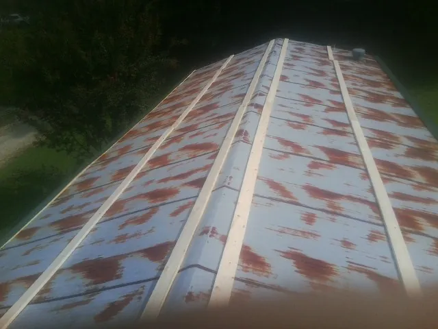 Rusted metal roof panels with new wood purlins before replacement — Storm Damage Roof Repair in Coventry by Roofing Brothers