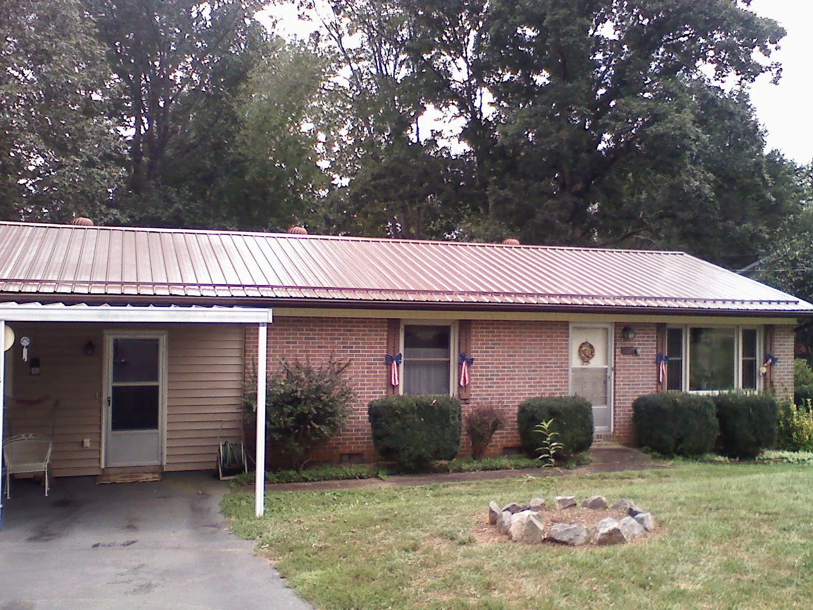Bronze metal roof and carport on a brick ranch home — Roof Repair work by our crew in Coventry